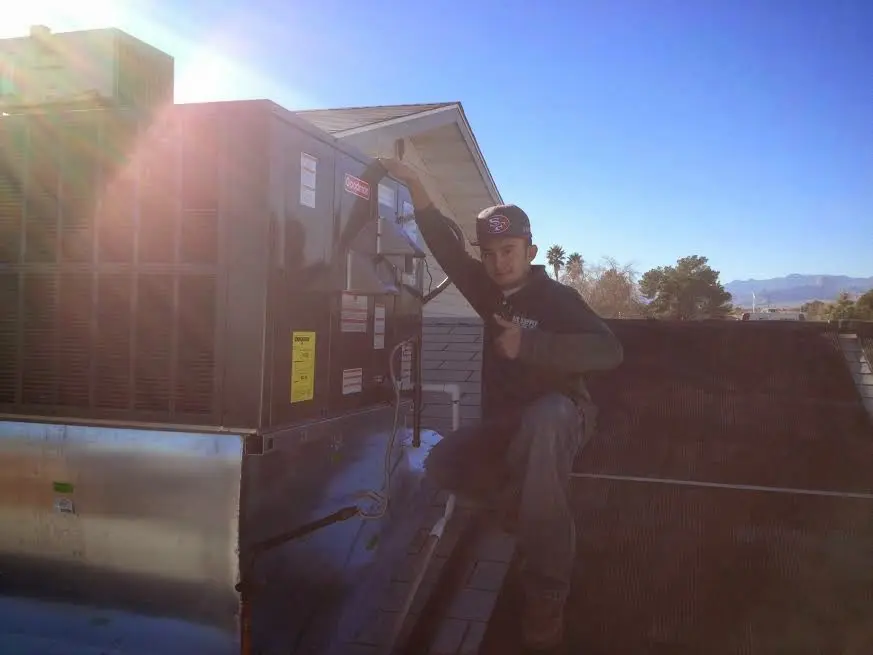 HVAC technician performing AC Tune-Up on a rooftop unit in McCook